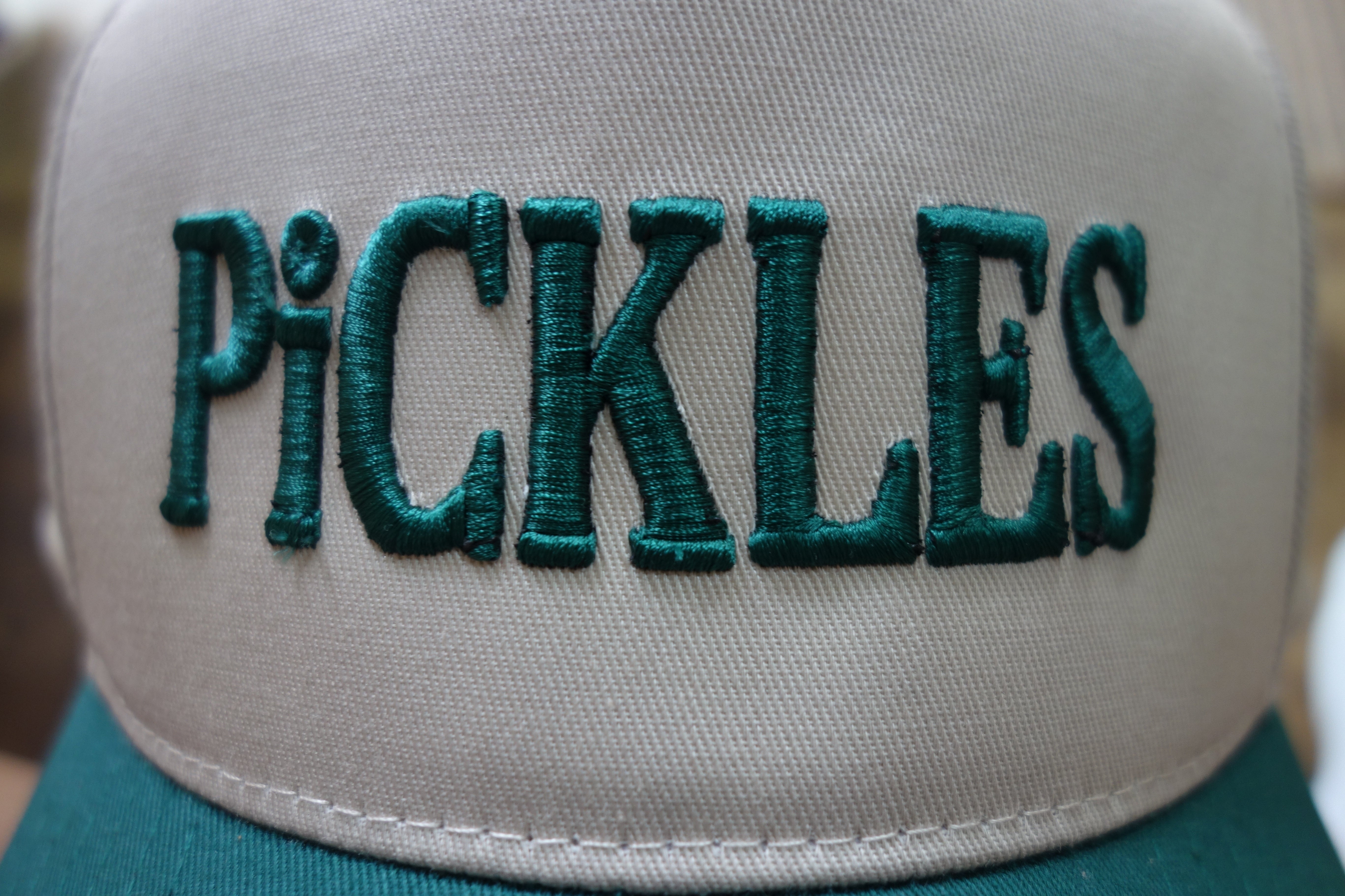 Cap with 'PICKLES' embroidered in green on a beige background