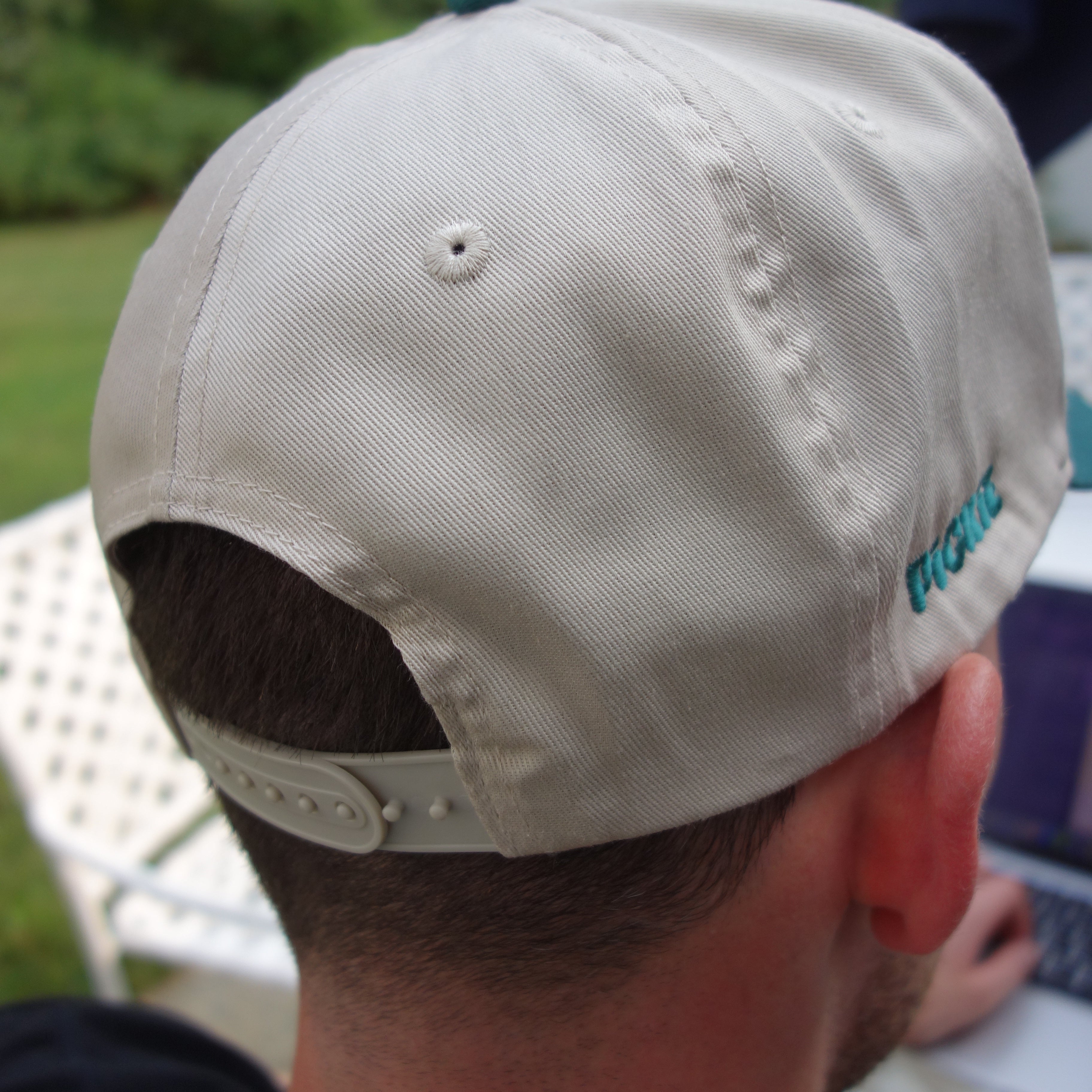 Beige cap worn by a person with a blurred background