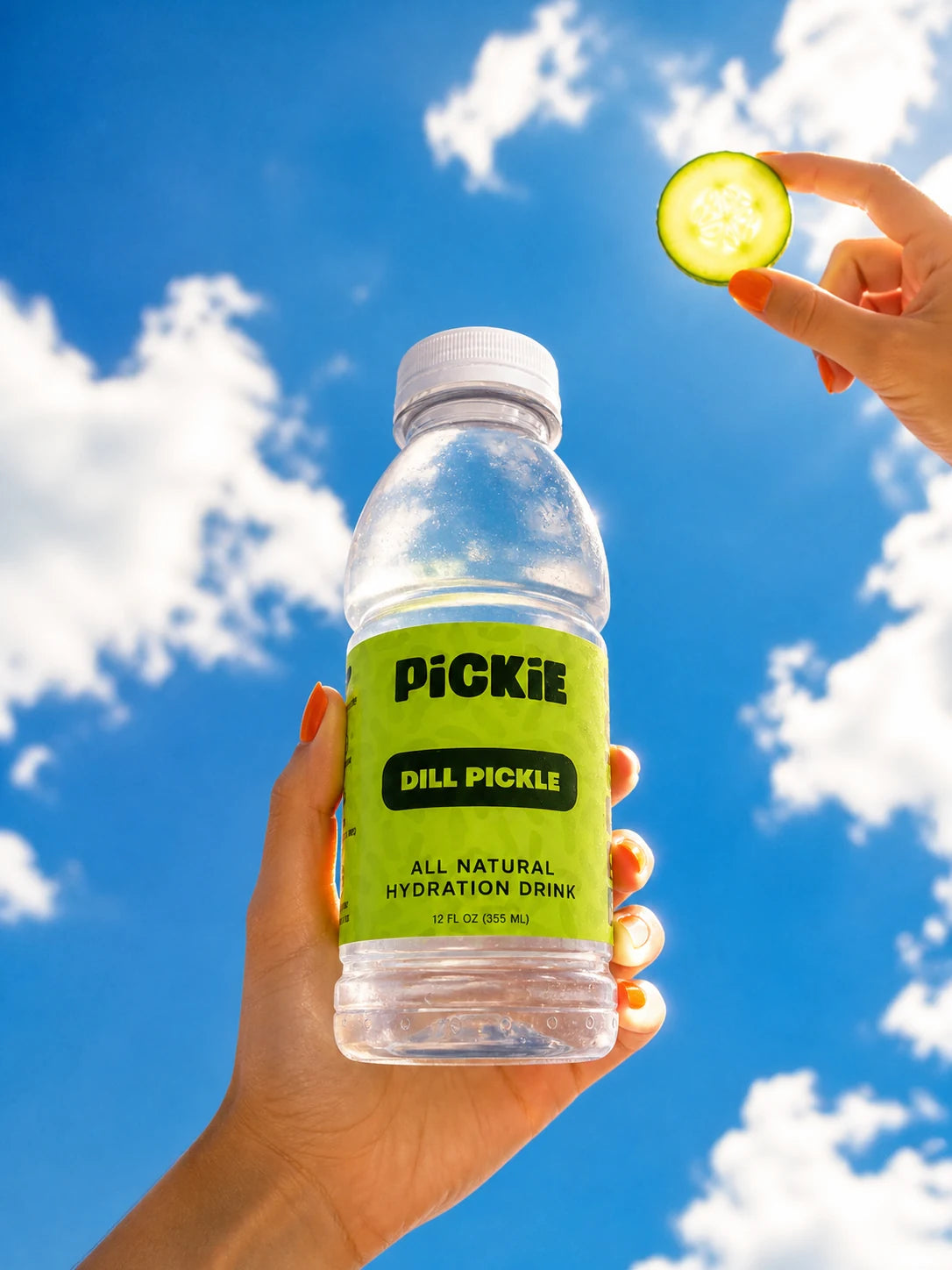 A clear PiCKiE bottle held against a blue sky